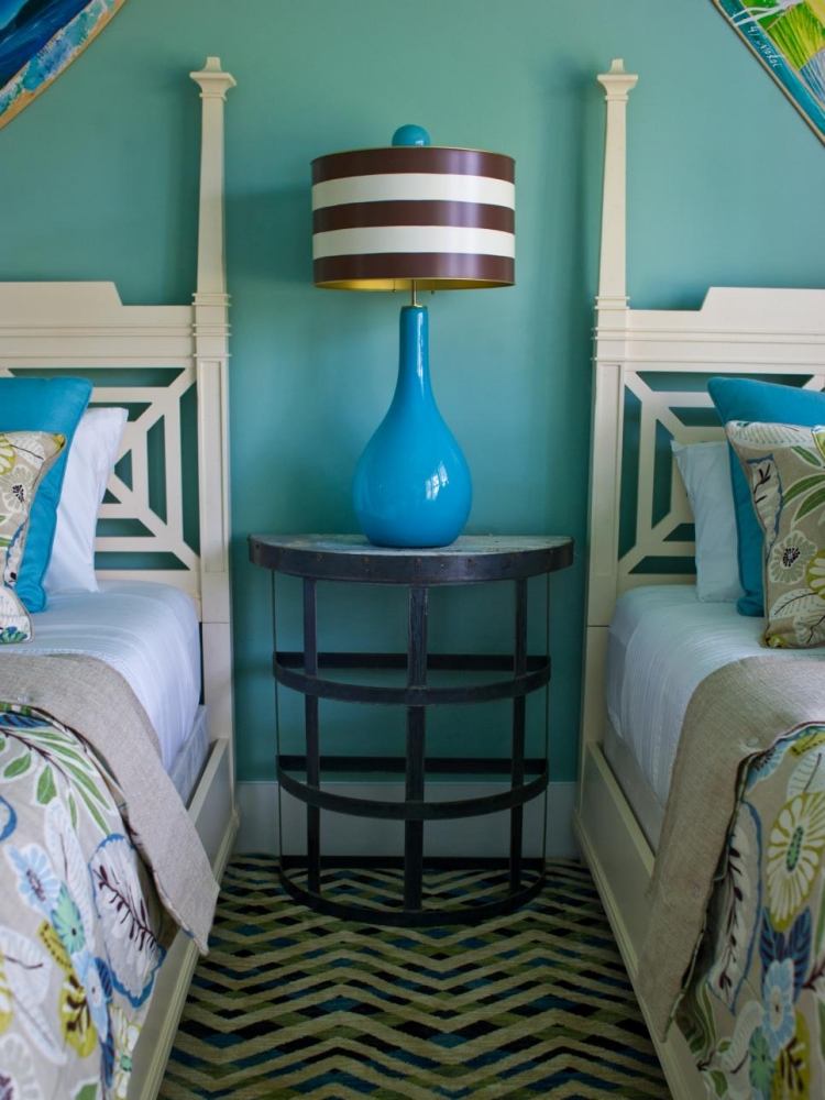 vägg-färg-turkos-sovrum-sängar-sängbord-blommor-mönster-kuddar
