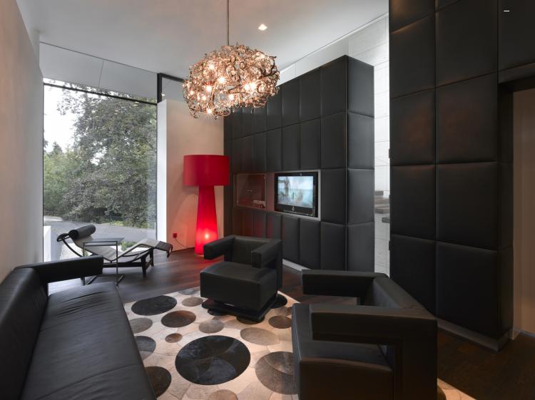 väggdesign-vardagsrum-idéer-modern-extravagant-svart-stoppad väggfåtölj-ljuskrona