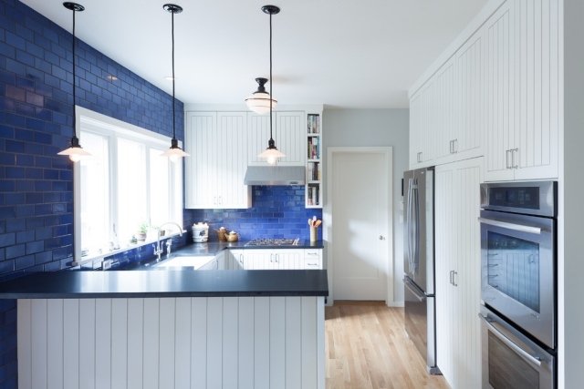 vitt-kök-fronter-bak-vägg-med-kakel-lagda-glasade-yta-blå