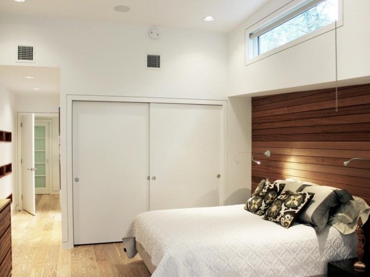 väggbeklädnad-trä-interiör-sovrum-sänggavel-skåp-skjutdörrar-kuddar-modern-vit
