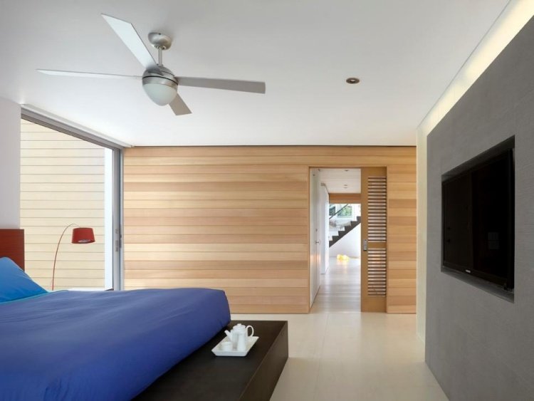 väggbeklädnad-trä-interiör-sovrum-tv-grå-blå-sänglinne-skjutdörr-hus