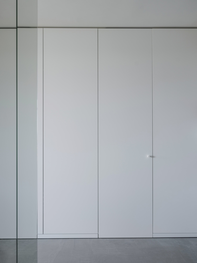 Inbyggd garderob utan skåphandtag, dörren i linje med väggen