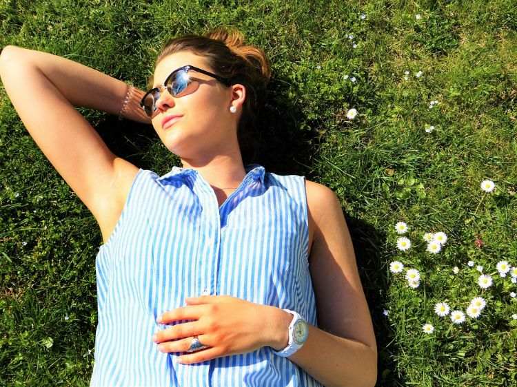 ung kvinna som ligger under solängens gräsmatta