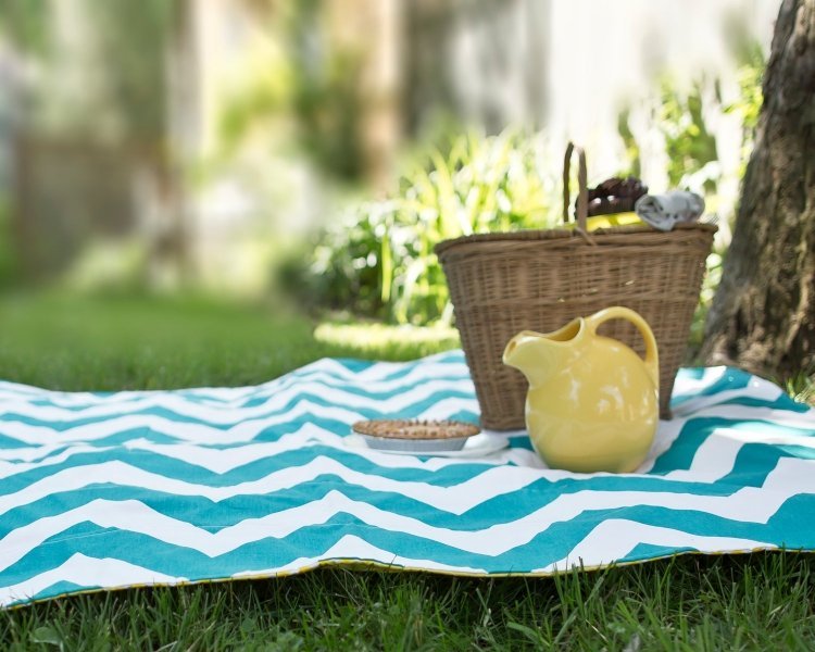 vattentät-picknick-filt-vit-turkos-kanna-gul-korg-gräsmatta