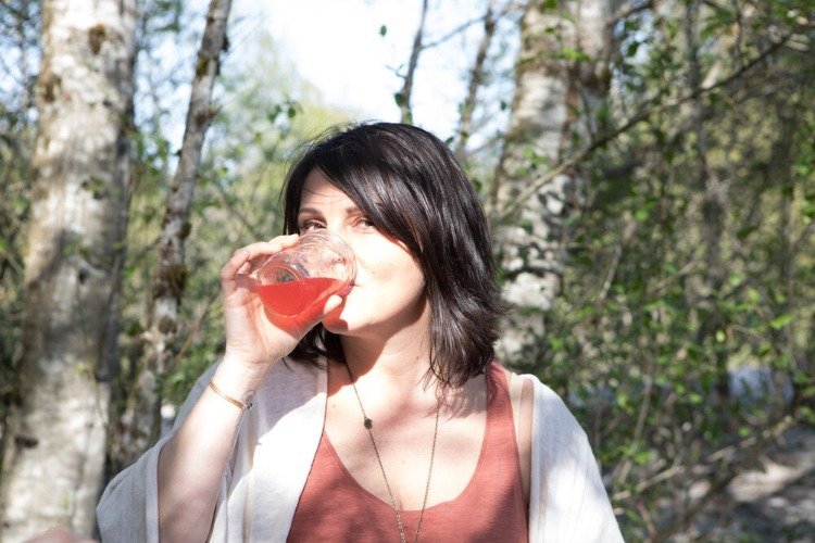 kvinna i skogen dricker vatten kefir biverkningar som diarré eller magproblem är möjliga