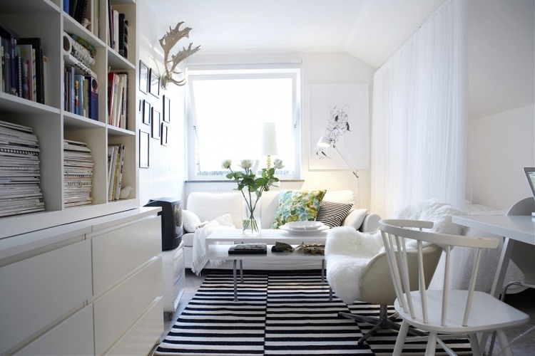 vitt-vardagsrum-möbler-modern-skandinavisk-möblering-matta-ränder-svarta-bokhyllor-kuddar