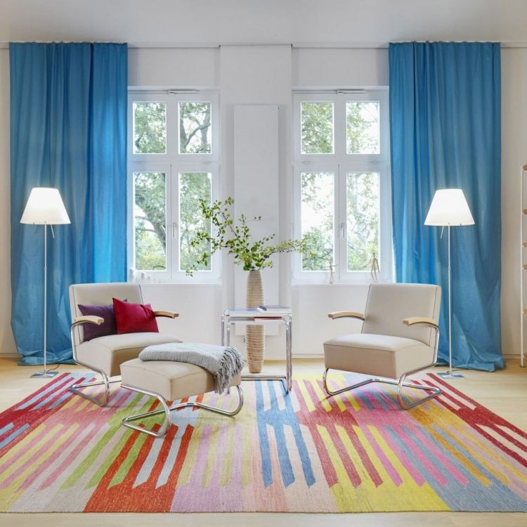 vitt vardagsrum-möbler-modern-traditionell-fåtölj-fotpall-traditionell-gardin-blå-matta-färgad
