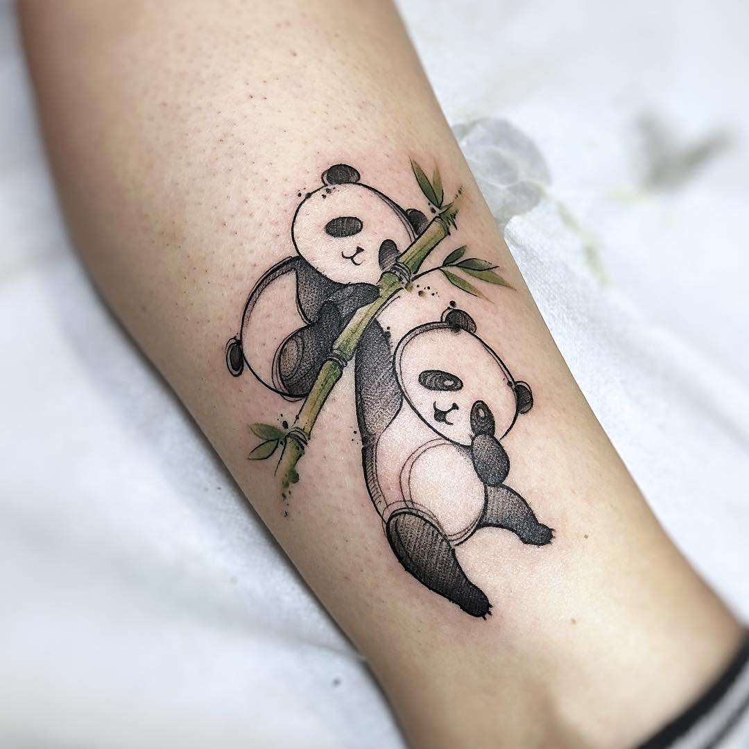Två tecknade pandor leker på en bambugren