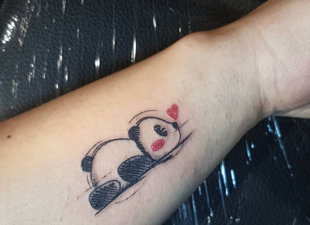 Liggande pandabjörn med hjärtan utformad som en skiss