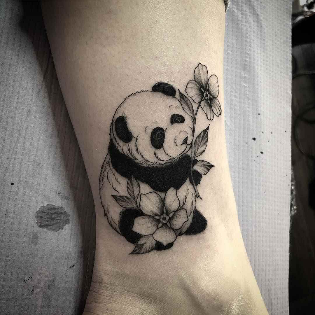 Panda med blommor ovanför en kvinnas fotled