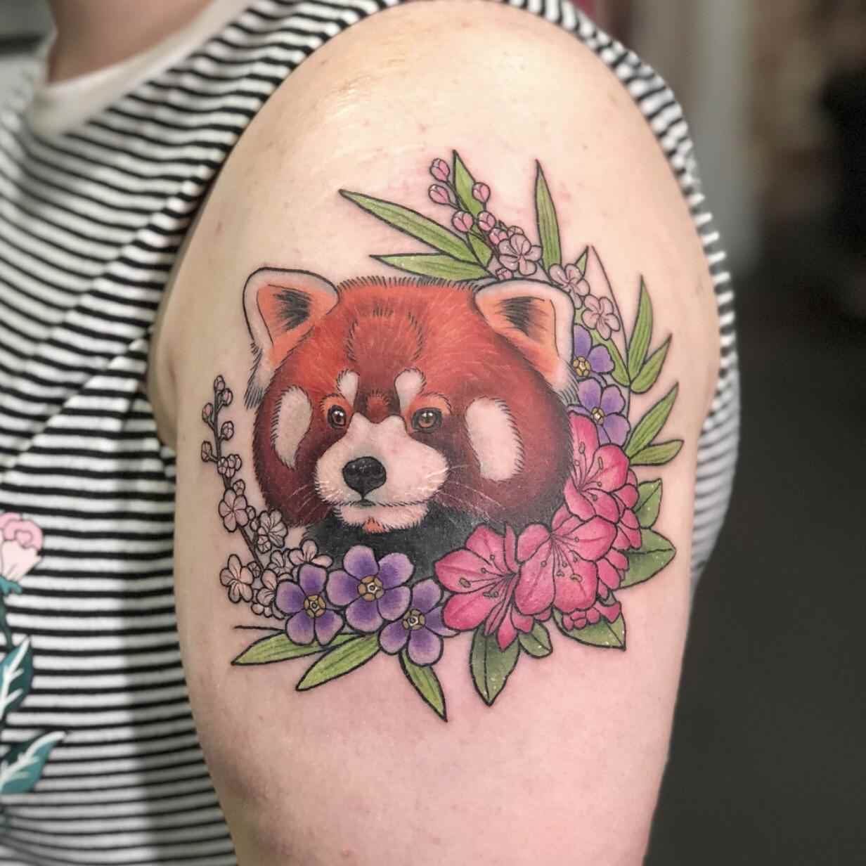 Röd panda i kombination med exotiska rosa och lila blommor