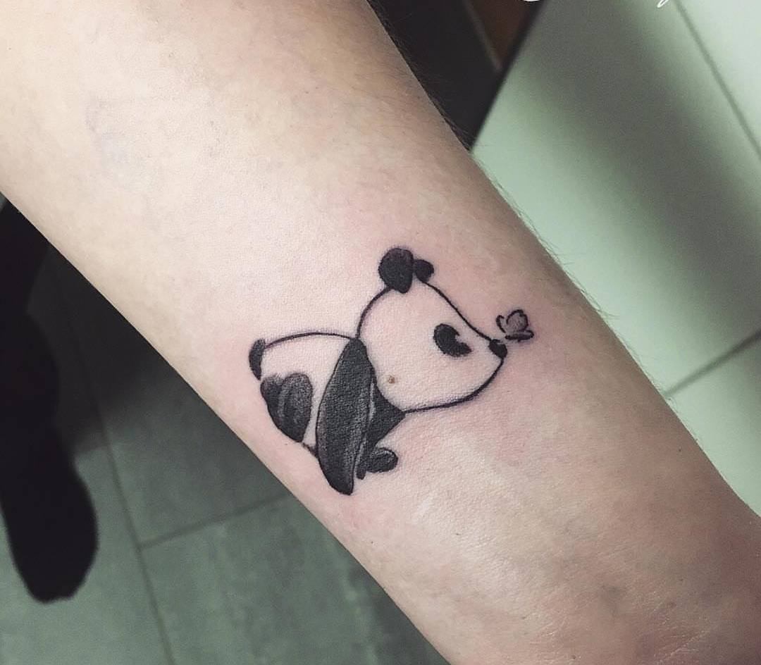 Tatuering av en söt baby panda med en fjäril på näsan