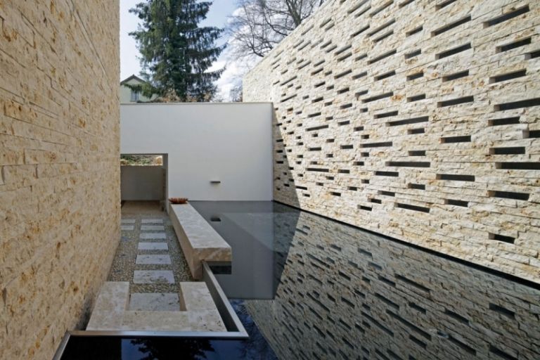 vit-hus-sjö-vatten-vägg-modern-natur-sten-staket-sekretess skärm