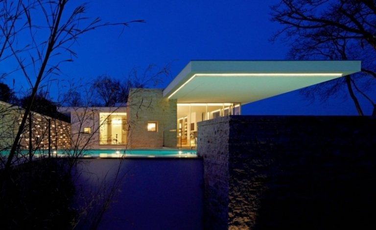 vitt-hus-sjö-utomhus-trädgård-natursten-belysning-pool-modernt