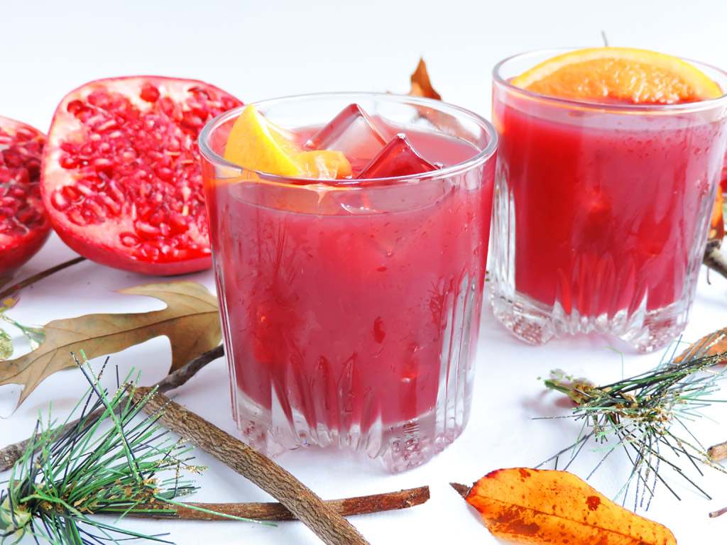 förbered julcocktail med recept på granatäpple och apelsinjuice för festdrycker med alkohol