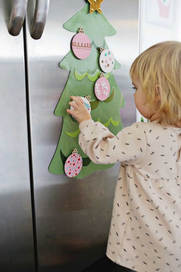 Julhantverk med småbarn 2 år gammalt barn dekorerar DIY julgran