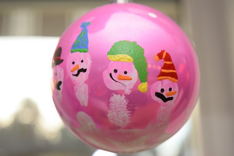 Julgransbollar målar tematiskt snögubbar från handavtryck