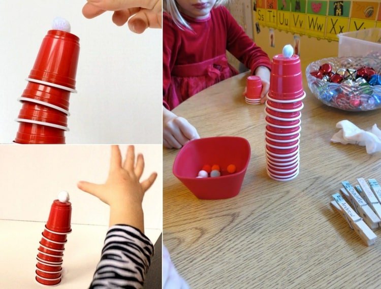 Bygg ett torn med barn - stapla röda koppar och vita pomponger