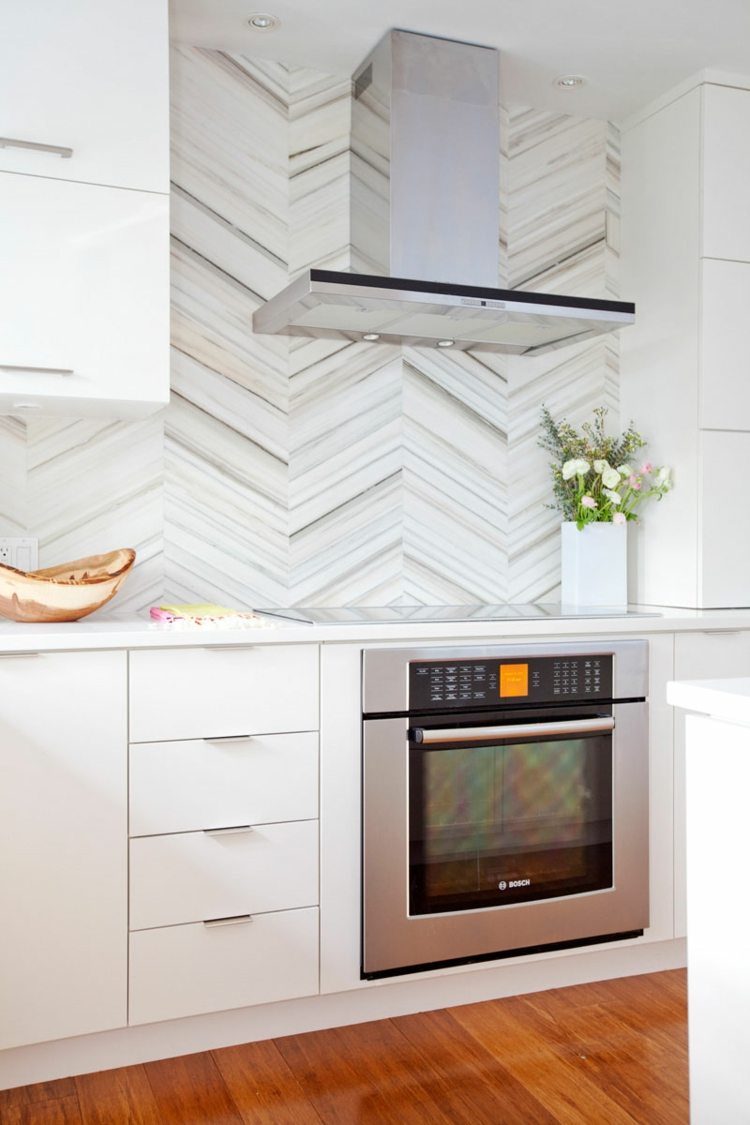 Sicksackmönster av smala marmorplattor i ett modernt kök