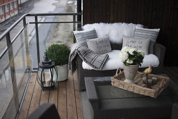 Boxwoodboll i kruka bredvid soffan på balkongen på vintern