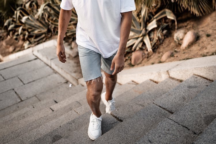 Vita sneakers på sommaren med jeansshorts och en vit T -shirt - casual outfit för män