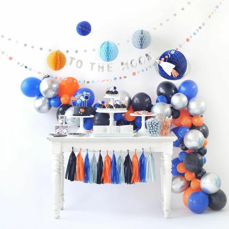 Rymdfest i färgerna orange, blått och silver med dekoration av tofsar och ballonger