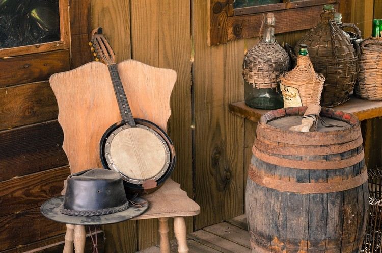 Western party dekoration idéer gamla trä fat banjo cowboy hatt trä stol flaska flät