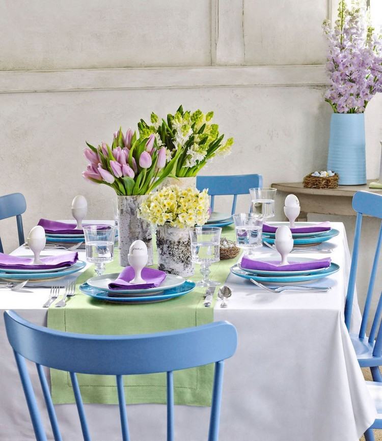Påskdekoration-pastellfärger-bord-blå-stolar-tallrikar-lila-servetter-vårblommor