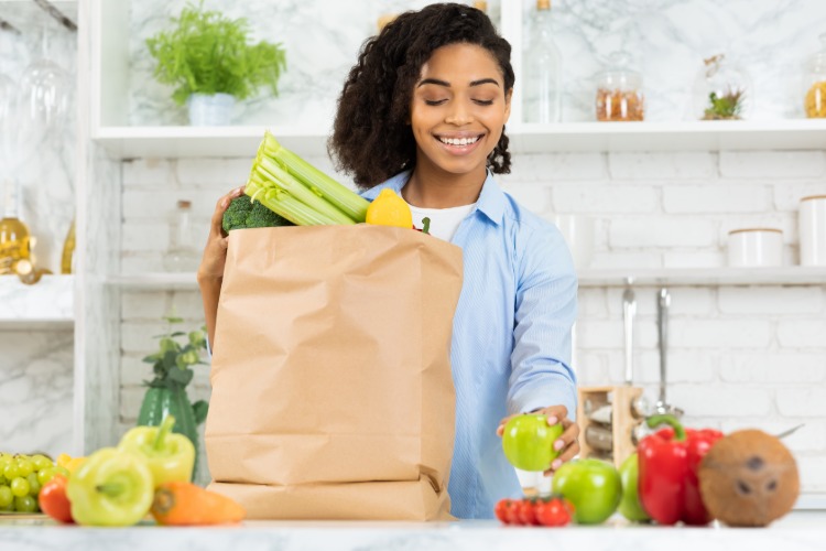 le kvinna med shoppingpåse viktiga näringsämnen från grönsaker och frukter mot infektioner i covid-19