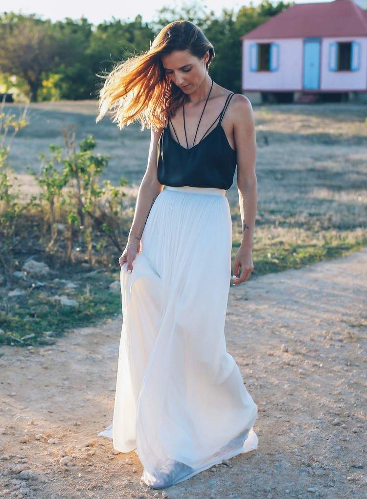 Vit lång kjol kombinerar spagettiband med svart topp under sommaren