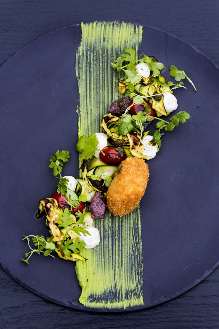 Serverar salladens svarta tallrik med grön sås