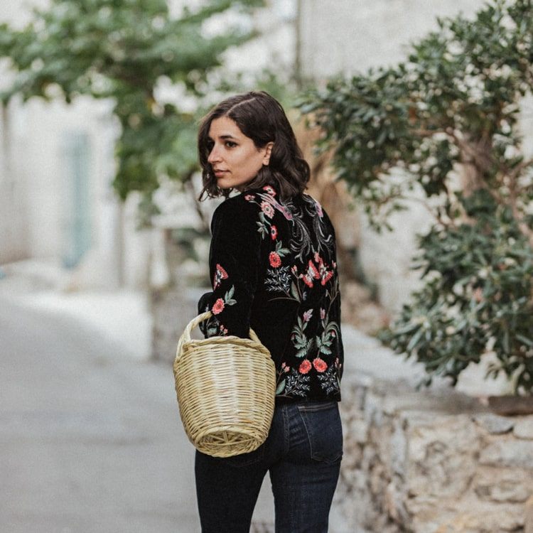 Elegant blus i svart med rosa, broderade blommor och gröna blad