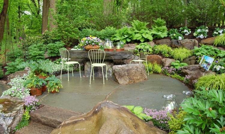 terrass sittgrupp sten trädgård frodiga växter design utomhus