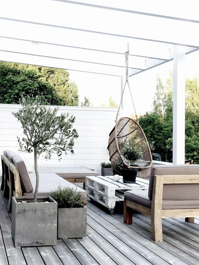 Skapa en skandinavisk terrass med trädäck, betonghinkar och pallar till bordet