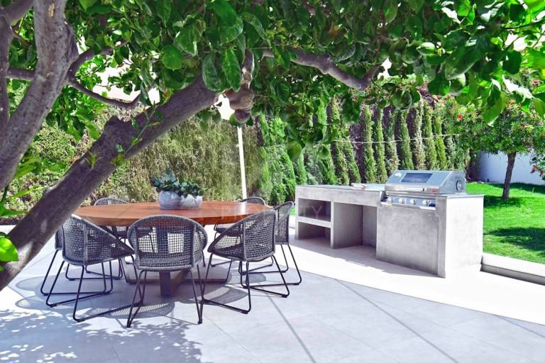Designa en skandinavisk terrass med trä, metall och betong - runt matbord och grill