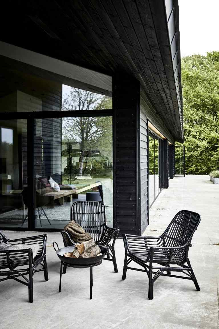 Trendiga stolar i svart med skandinavisk stil runt en liten eldskål