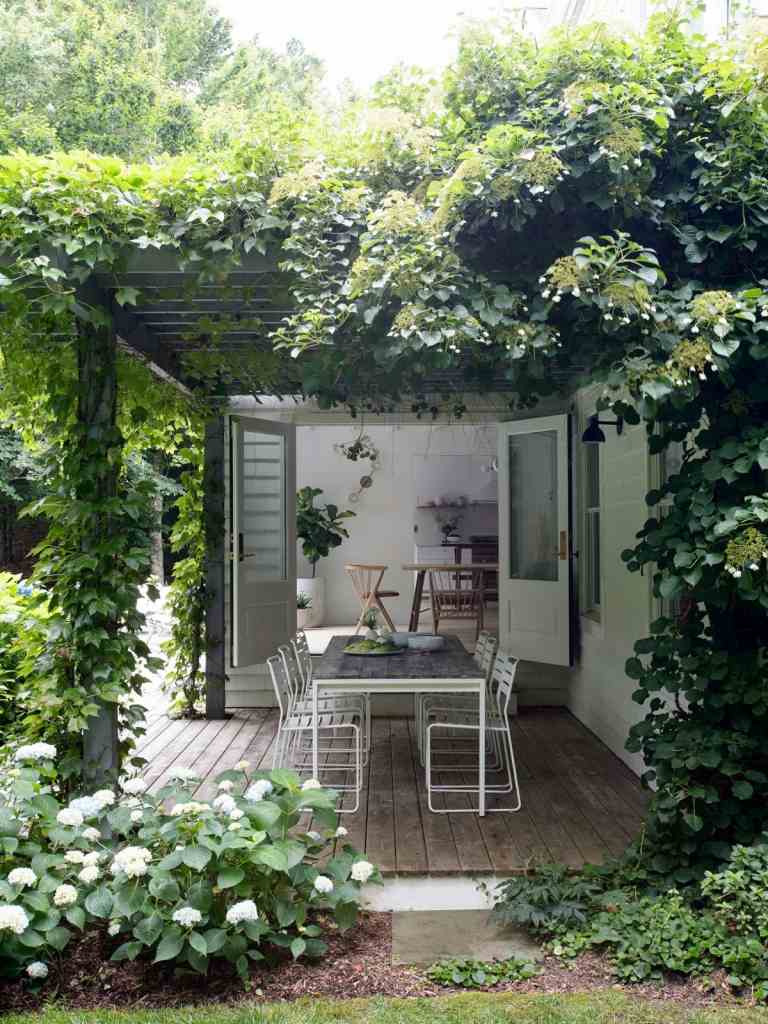En romantisk stuggård med skandinaviska möbler på terrassen