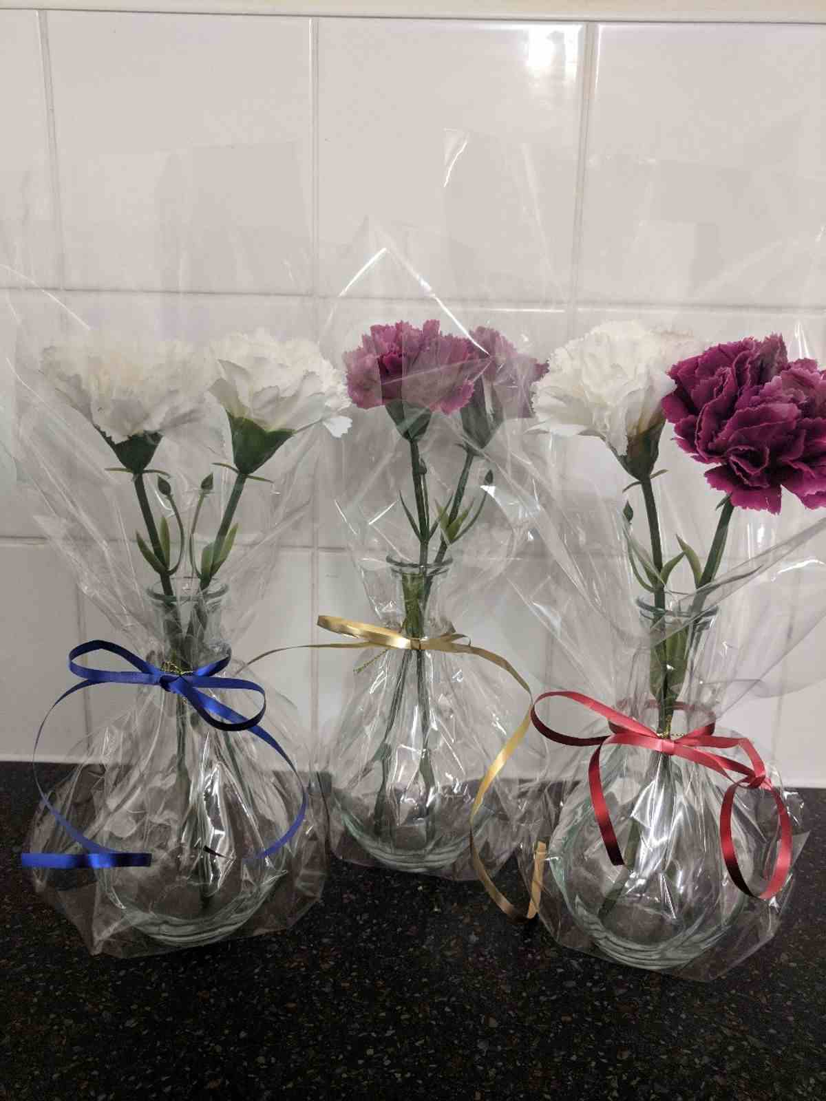 Slå in gåvor snyggt med folie - idé till vaser med nejlikor