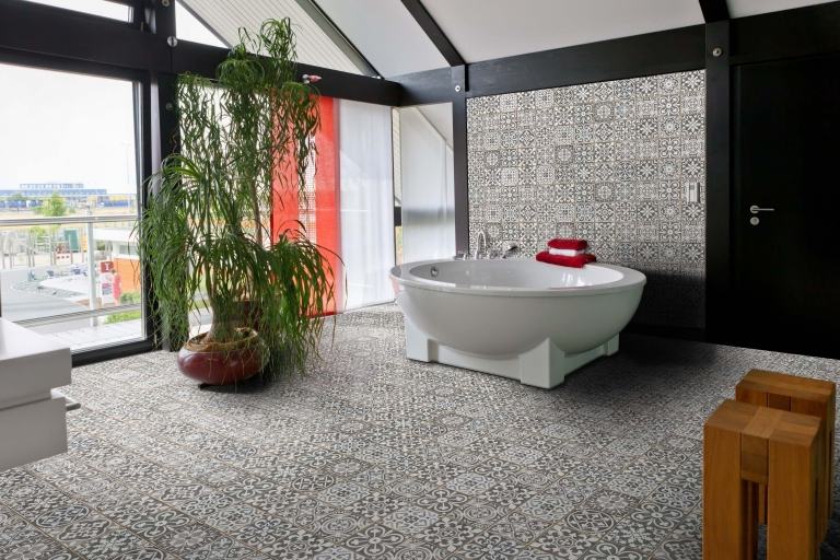 stort badrum i grått tapetmönster terrassformat badkar