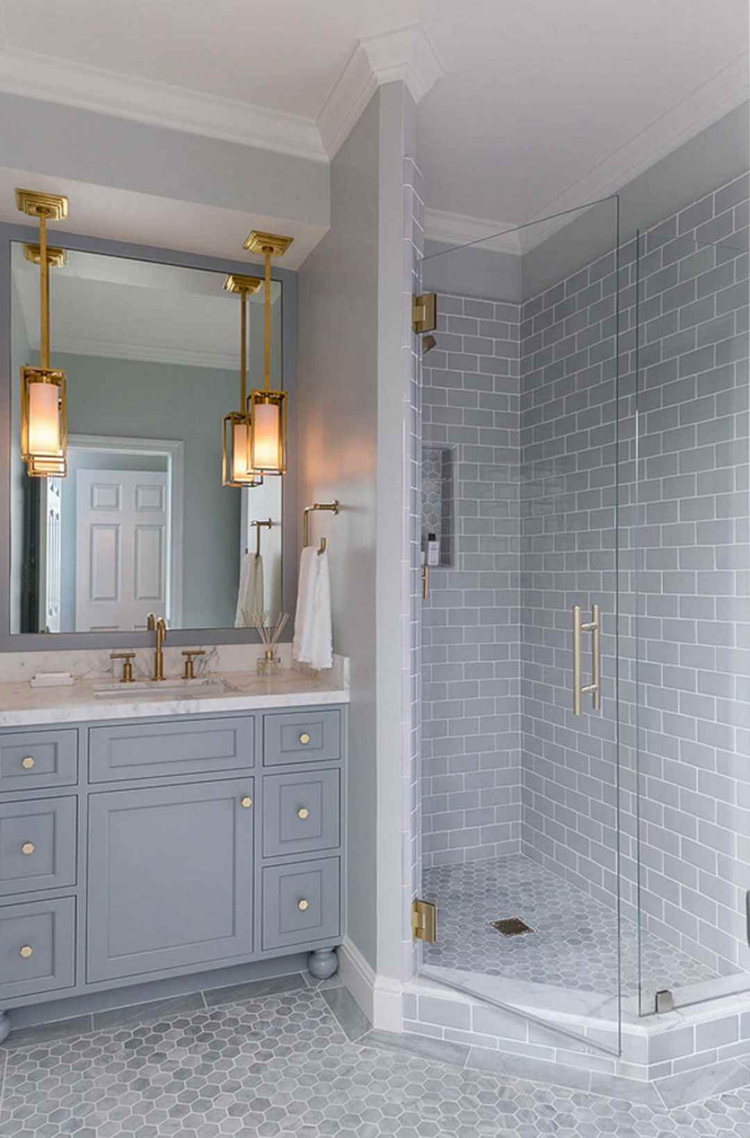 Badrum i grått litet duschkabinett marmor topplampa guldfärg accent