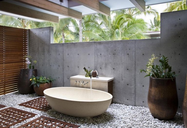 Badrum i grå betongvägg badkar retro dekorativa stenar palmer