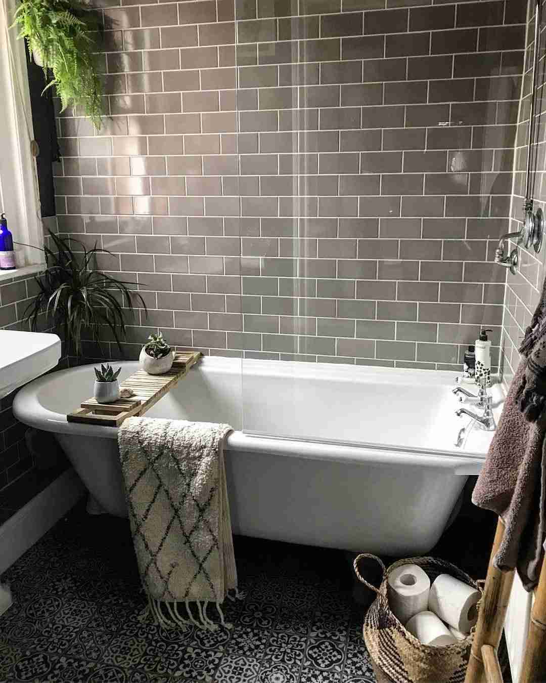 Badrum i grå kakel ljusgrått badkar design hem tillbehör blommor levande trender