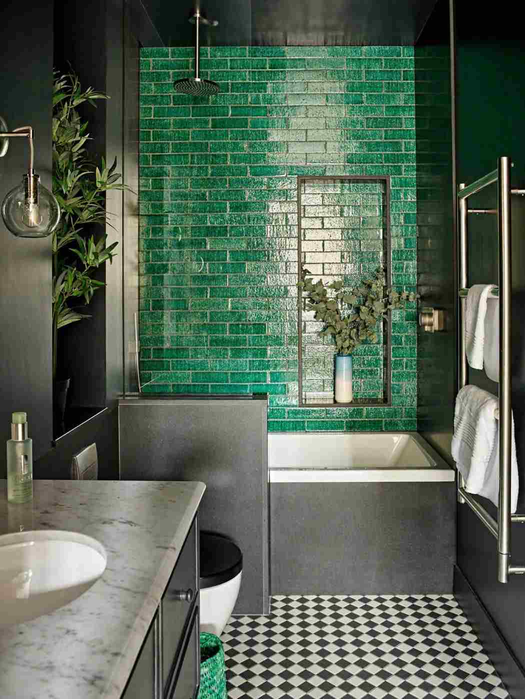Badrum i grå små kakel gröna moderna golvmönster marmorplatta hemtillbehör