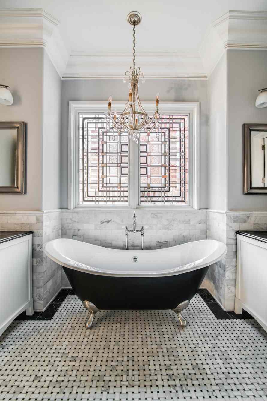 Badrum i grått retro badkar golv badrum kakel ljuskrona guld