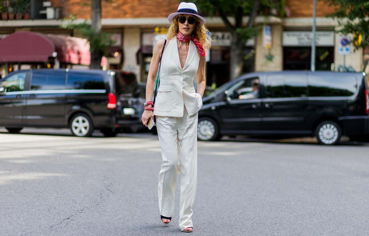 Kostymväst kombinerar korta vita byxor dammössa runda solglasögon modetrender damer