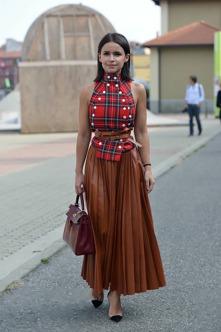 Plisserad kjol i läder kombinerar höstläderväska med kort hårstrender