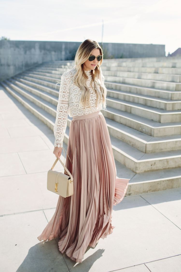 Lång veckad kjol kombinerar sommarblus med läderväska med spetsdetaljer
