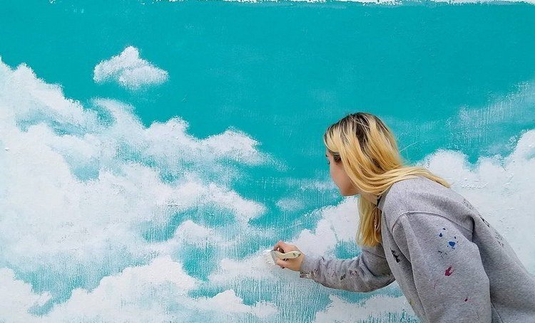 Måla moln på väggen med en platt pensel och akrylfärg