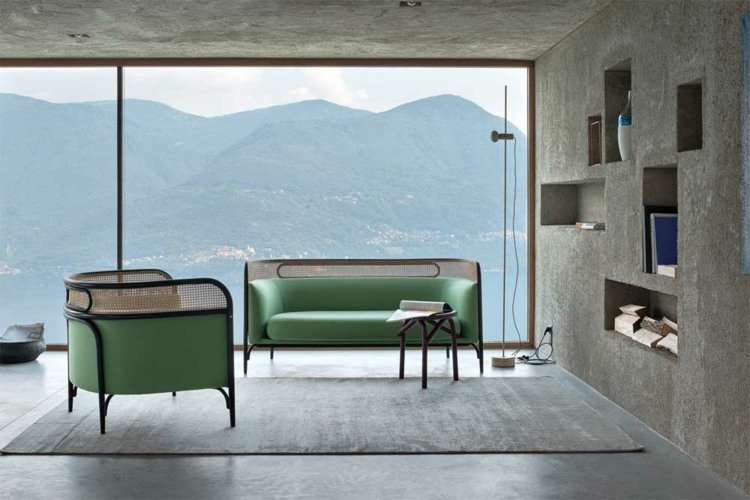 Modern lägenhet med betong, fönsterfront och färgade möbler med korgverk