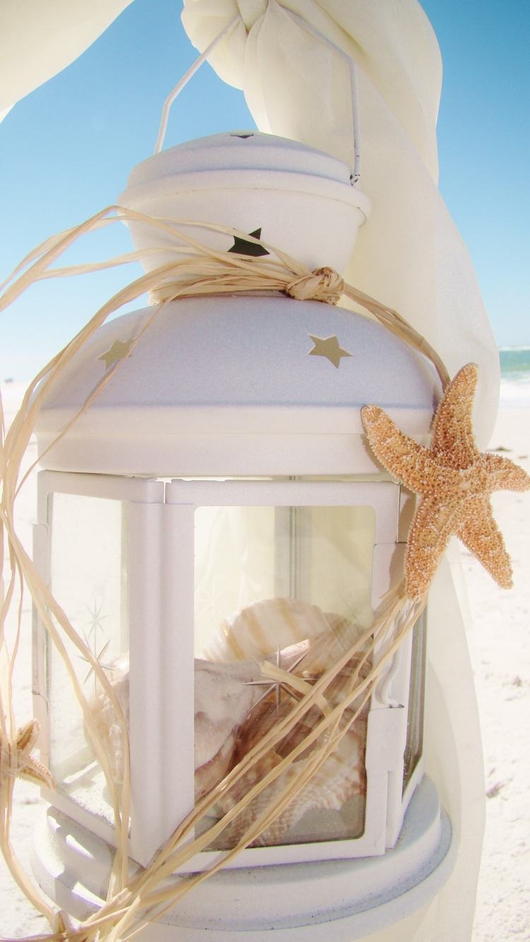 Sommar-dekoration-idéer-vindljus-ljuslykta-strand-sjöstjärnor-sand-vita-skal